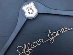 a police badge and name on the back of a blue jacket with gold lettering that reads officer jones