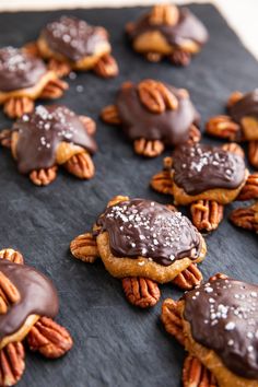 chocolate covered pecans and nuts on top of a cookie sheet