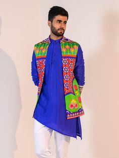 This Blue Asymmetrical Kurta Set with Veronica Half Jacket will instantly give an elegant look. This 3 piece kurta jacket set features a vibrant Veronica silk half jacket with heavy floral print, a blue asymmetrical silk kurta with embroidered cuffs of thread sequence work using mirror-beads-stones, invisible front button placket, and a mandarin collar. It is paired with white slim-fit cotton pants. An ideal outfit for traditional occasions, and special events.

Size Chart For Men Matching Lehenga, Embroidered Cuffs, Blue Kurta, Half Jacket, Gold Blouse, Silk Kurta, Sequence Work, Work Skirts, Pants Cotton