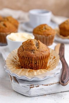 a muffin sitting on top of a white plate next to some cupcakes