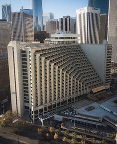 an aerial view of a large building in the middle of a city with tall buildings