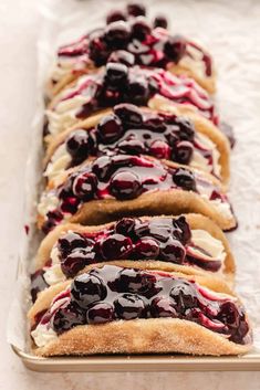 there are many slices of bread with blueberry toppings on them, lined up in a row