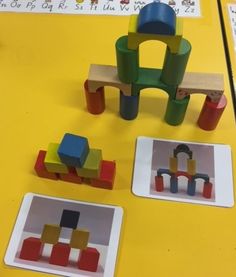 some toys are sitting on the table and one is in front of them with blocks