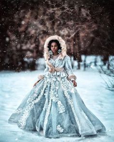 a woman in a blue gown and fur hat standing in the snow