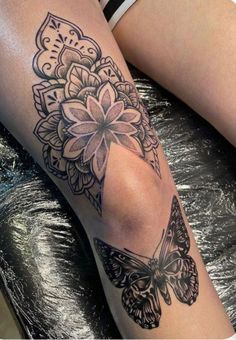 a woman's leg with a butterfly and flower tattoo on it