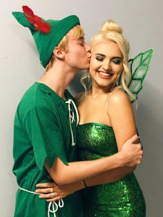 a man and woman dressed up as tinkerbells kissing on the cheek while standing next to each other