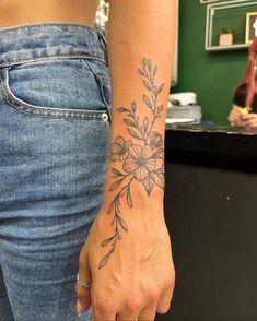 a woman with a flower tattoo on her left arm and the other hand behind her