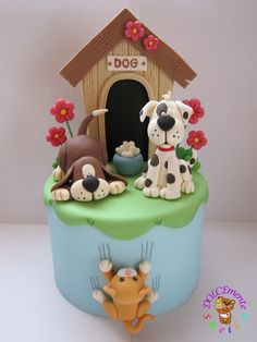 there is a cake that has dogs on it and a doghouse in the background