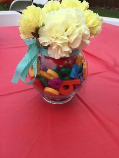 a vase filled with flowers on top of a pink table cloth covered tablecloths