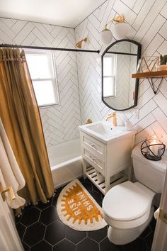 a white toilet sitting next to a sink in a bathroom on top of a black and white floor