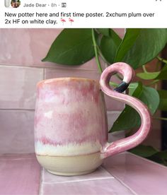 a pink flamingo mug sitting on top of a counter next to a potted plant