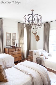 a bedroom with two beds and a chandelier hanging from the ceiling above them