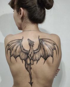 a woman with a dragon tattoo on her back