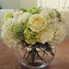 a vase filled with white and green flowers