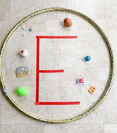 an overhead view of a circle made out of plastic beads and other toys on the floor