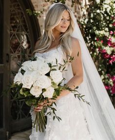 a woman in a wedding dress holding a bouquet