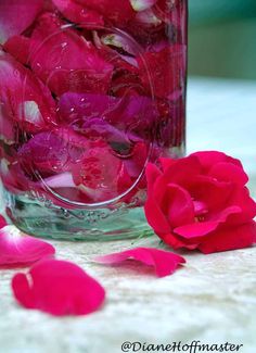 a glass jar filled with water and pink flowers