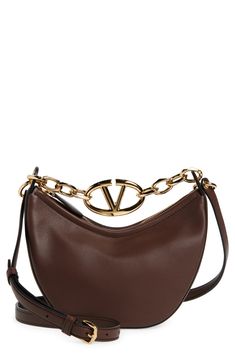 A gleaming chain centered with a VLOGO insignia spans the top of this hobo crafted from grained leather in a slouchy crescent silhouette. Top zip closure Chain top carry handle; removable, adjustable shoulder strap Leather Made in Italy Designer Handbags Elegant Brown Shoulder Bag With Metal Logo, Luxury Brown Shoulder Bag With Metal Logo, Luxury Brown Bag With Metal Logo, Chain Top, Hobo Bag, Valentino Garavani, Designer Handbags, Crescent, Top Handle