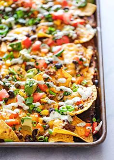 a baking pan filled with nachos and toppings