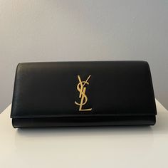 Black, Like New - Used Less Than A Handful Of Times And No Visible Wear Or Tear Black Clutch Purse Ysl, Yves Saint Laurent Wristlet, Black Clutch With Gold-tone Hardware, Luxury Black Wallets With Gold-tone Hardware, Luxury Black Leather-lined Clutch, Wear Or Tear, Classic Monogram, Large Clutch, Saint Laurent Bags