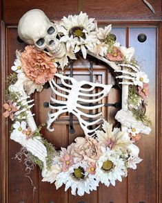 a wreath decorated with flowers and a skeleton