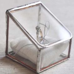 a silver ring in a glass box on a table