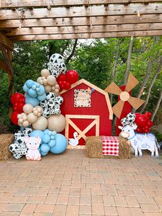 a red barn with balloons and farm animals