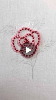 the video is showing how to make an origami flower with yarn and beads