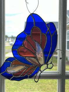 a stained glass butterfly sitting on top of a window sill