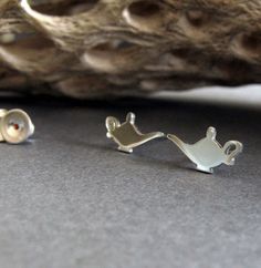 If you have a love for making wishes and love miniature things as well, you have to have these earrings. The tiniest little magic lamp silhouette jewelry for your ears. The Details ∞ Artisan handmade ∞ Small Magic Lamps (approx 12.4mm x 6.4mm) ∞ Choose from sterling silver, 14k gold-filled or solid 14k yellow gold ∞ Earring backs included in the metal of your choice ∞ Made to order ∞ Gift box included ∞ Made in the USA IMPORTANT NOTE FOR 14K GOLD FILLED EARRINGS If you are purchasing our gold fi Nickel-free Magical Earrings For Gift, Magical Nickel-free Earrings For Gifts, Lamp Silhouette, Magic Oil, Silhouette Jewelry, 3 Wishes, Genie Lamp, Magic Lamp, Miniature Things