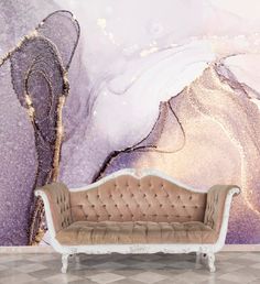 a couch sitting in front of a wall with a painting on it's side