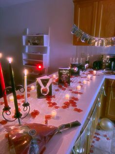 a table topped with candles and valentine's day decorations on top of a kitchen counter