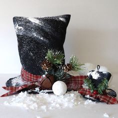 a black pillow and some decorations on top of snow