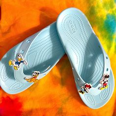 New ~ Here’s Your Chance To Start That Disney Vacation Early In These Absolutely Adorable Crocs Flip Flops In Disney’s Cinderella Blue. Four (4) Micky & Friends Themed Jibbitz’s Included. Unisex Woman’s 8 / Men’s 6 Original. Versatile. Comfortable. The Same Look And Feel Of The Incredibly Popular Classic Flip, Now With Six Holes In Each Sandal To Allow For Ultimate Personalization With Jibbitz Charms. A Textured Heel Adds More Style Power As The Classic Croslite Foam Construction Cushions Your Step. Lightweight, Colorful And Fun To Wear That's How To Be Comfortable In Your Own Shoes. Lightweight, Buoyant Croslite Foam Construction Easy To Clean & Quick To Dry Soft Casual Light Blue Synthetic Flip Flops, Cute Blue Round Toe Sandals, Cute Blue Sandals For Vacation, Cute Blue Flip Flops For Vacation, Cute Blue Flip Flops For Beach, Disney Open Toe Sandals For Summer, Fun Blue Round Toe Sandals, Blue Playful Round Toe Sandals, Playful Blue Round Toe Sandals