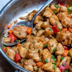 a pan filled with chicken and vegetables on top of a table