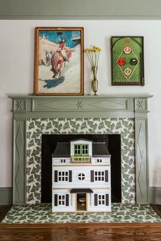 a doll house sitting on top of a fireplace