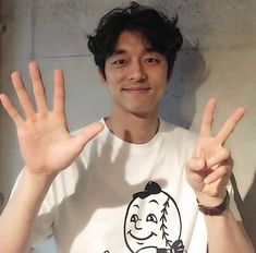 a young man making the peace sign with his hands