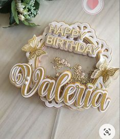 a happy birthday cake topper with the word valeria spelled in gold and white