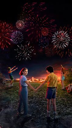 two children are holding hands with fireworks in the sky above them and on the ground