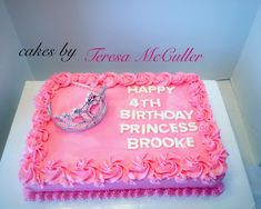 a birthday cake with pink frosting and tiara on top