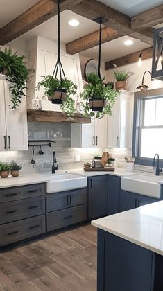 a kitchen filled with lots of counter top space and hanging plants on the ceiling over the sink