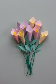 a bunch of flowers that are sitting on a table with some green stems in front of them