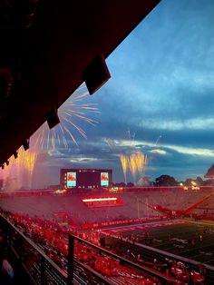 fireworks are lit up in the sky at a football game