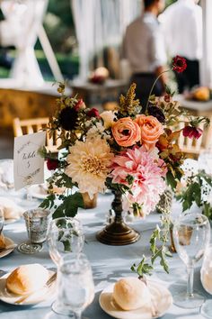 a table topped with plates and vases filled with flowers