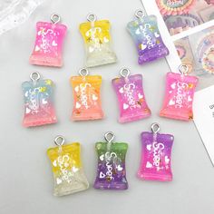 six small candy bags with charms attached to them