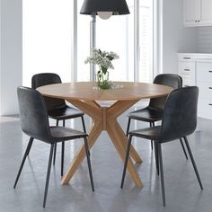 a round wooden table with four chairs around it in a white and gray kitchen area