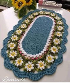 a crocheted table runner with flowers on it