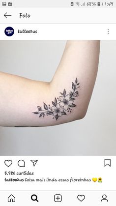 an arm tattoo with flowers and leaves on the left side of the arm, in black ink