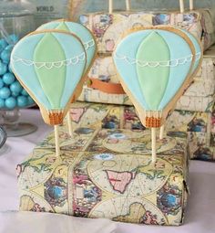 two hot air balloons sitting on top of a cake in the shape of a suitcase