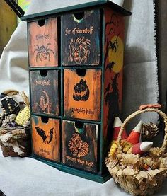 an assortment of halloween themed drawers on display next to a wicker basket and pumpkins